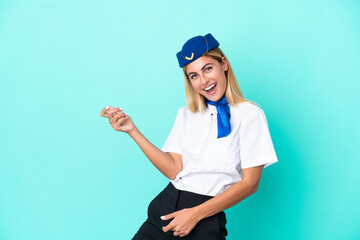 Airplane stewardess Uruguayan woman isolated on blue background making guitar gesture