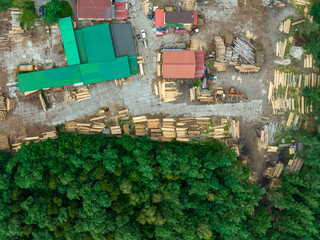 Naklejka premium Pile of Logs in Sawmill Industry Aerial View. Green pine forest from above..