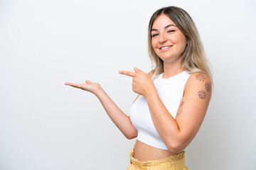 Young Rumanian woman isolated on white background holding copyspace imaginary on the palm to insert...