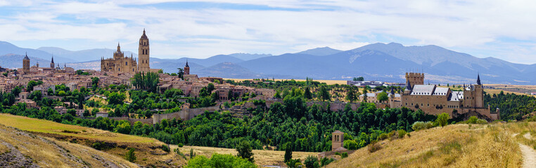 Fototapeta na wymiar Panoramic view of the medieval city of Segovia with its old buildings and the mountains of Navacerrada in the background.