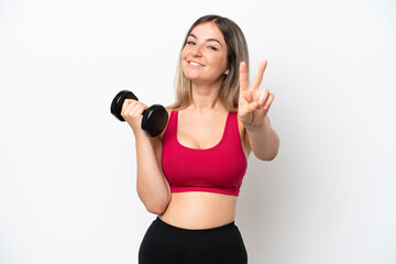 Young sport Rumanian woman making weightlifting isolated on white background smiling and showing victory sign