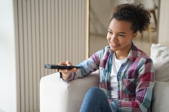 African american young girl watching movie or tv series, enjoying television program at home