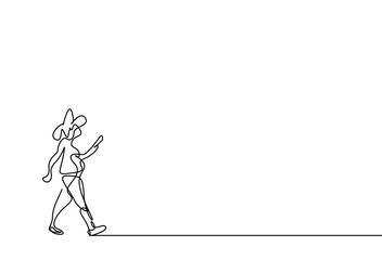 a woman is walking by reading a book in her hand