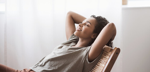Young woman relaxing at home panoramic banner. African american girl resting in her room. Enjoy...