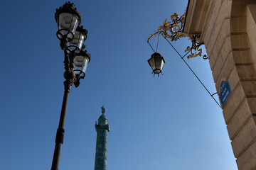 Fototapeta na wymiar place Vendôme à Paris, avec au premier plan la plaque indiquant le nom de la place et en arrière plan, la colonne Vendôme avec un beau ciel bleu