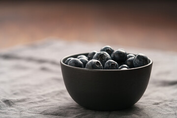 Freshly washed organic blueberries in a black bowl closeup