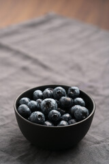 Freshly washed organic blueberries in a black bowl closeup