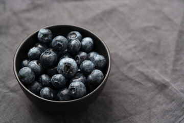 Freshly washed organic blueberries in a black bowl closeup