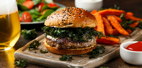 Juicy Beef burger with crispy kale, sweet potato fries and beer