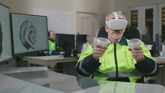 Male industrial engineer wearing virtual reality headset and holding controllers