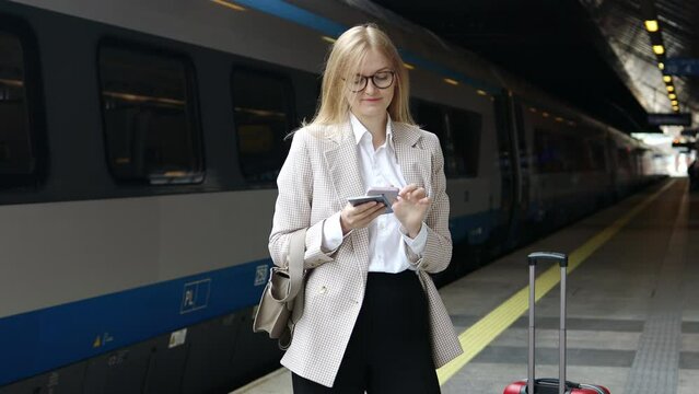 Travel woman using smartphone at train station. Young caucasian traveler checking boarding time with mobile phone app in terminal or train station. Business woman businesswoman Tourist on vacation