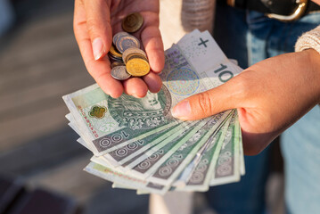 the girl holds in her hands banknotes money polish zlotys and pennies coins salary for payment