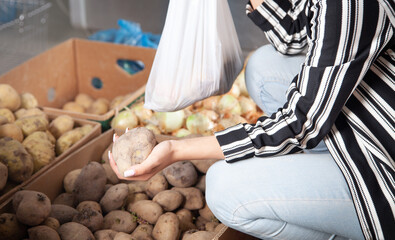  Woman buying potatoes in food store.