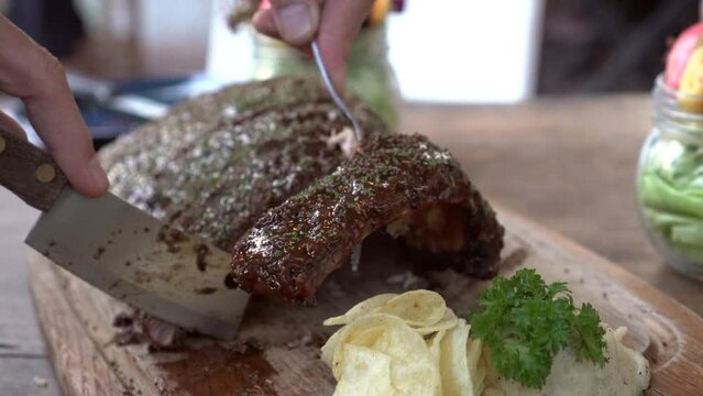 Hands Cutting Bbq Pork Ribs Cover In Sauce And Spices Rustic Yummy American Style Grill