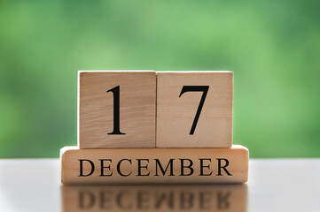 December 17 text on wooden blocks with blurred nature background. Calendar concept