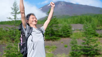 Naklejka premium 富士山をバックに手を挙げる登山者 
