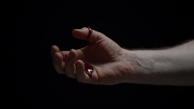 Close-up caucasian male hand covered in blood, crime scene, bloody hand isolated on black background