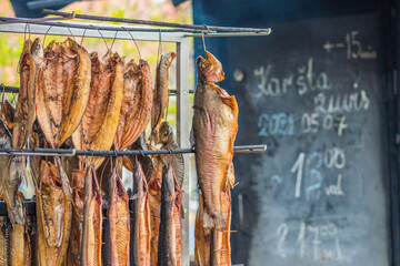 Hanging smoke-dried various fish in a fish market just smoked with hardwood wood chips in a smoker...