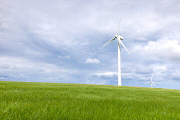 Fototapeta premium Onshore wind turbine with green grass foreground