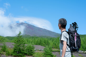 富士山山頂を眺める登山男性　