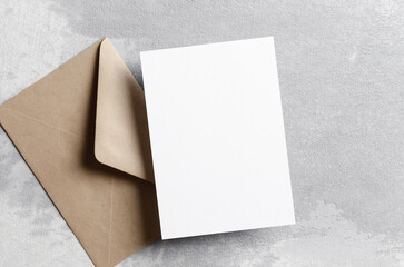 Invitation or greeting card mockup with craft papee envelope on grey