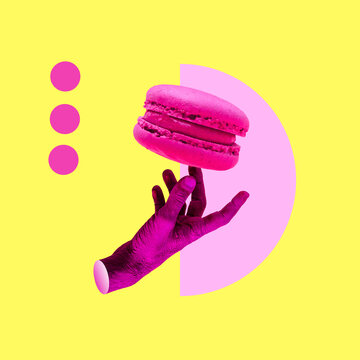 A painted pink hand is holding a macaroon cookie. Collage art, creative minimalism concept.