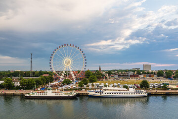 Riesenrad und Leuchtturm an der Ostseeküste in Warnemünde am Abend