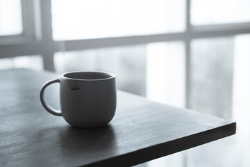 a cup of coffee on wood background black and white color