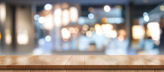 Empty wooden table with bokeh light effect and blur restaurant background, for your photo montage...
