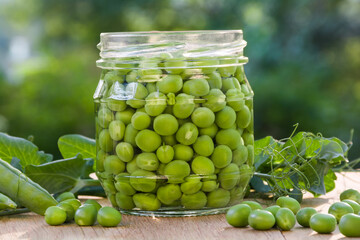 Green peas in a glass jar on a wooden table