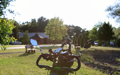 Kierownica wielopoziomowa roweru na polnej drodze wału wzdłóż jeziora pod słońce. - obrazy, fototapety, plakaty