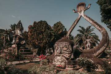 Vientiane, Laos - January 25th, 2020 : stone statues of buddhist and hindu gods and characters at Buddha Park
