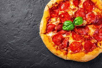 Pepperoni Pizza with Mozzarella cheese, salami, Tomato sauce, pepper, Spices. Italian pizza on Dark grey black slate background