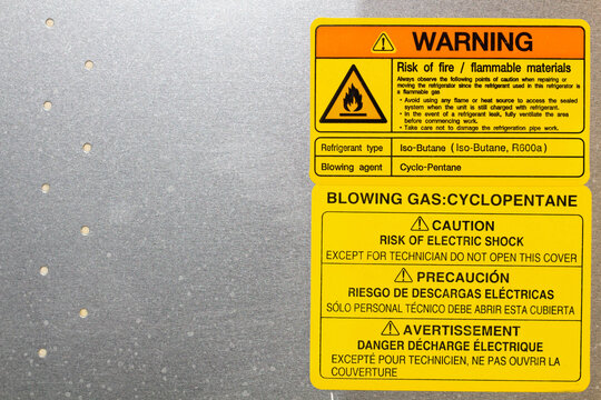 Warning. Blowing gas. Cyclopentane. Blowing agent.  Warning label on household appliances. Refrigerator repair in the workshop. Service maintenance. The back side of equipment. Copy space for text