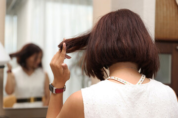 Fototapeta premium 鏡の前に座る女性の後ろ姿