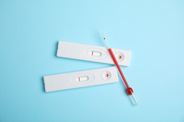 Disposable express hepatitis test kit on light blue background, flat lay