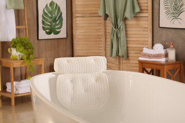 Fototapeta na wymiar White tub with soft bath pillow indoors