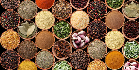 Collection of different aromatic spices and herbs on black background, flat lay