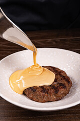 Hamburger meat with melting slice of cheese isolated on white background