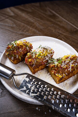 Four bruschettas with beef tartare on a plate, Crostini with Beef Tartare, beef Bruschetta, sandwich with raw gourmet beef