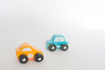 Two small toy cars yellow and blue; white background