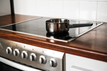 a metal saucepan stands on the stove in the kitchen. kitchen accessories