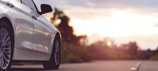 Derrière une belle voiture blanche garée sur une route avec de beaux couchers de soleil. avec un espace pour le texte.