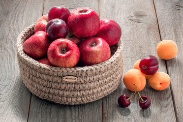 red apples in a basket on a wooden table, natural organic garden fruits and berries