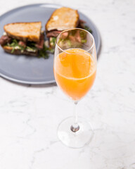 glass of orange juice with sandwich