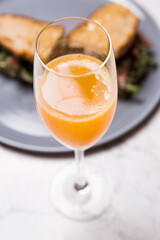 glass of orange juice with sandwich