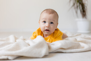 cute little boy in yellow body laying on blanket, card, banner, health, space for text