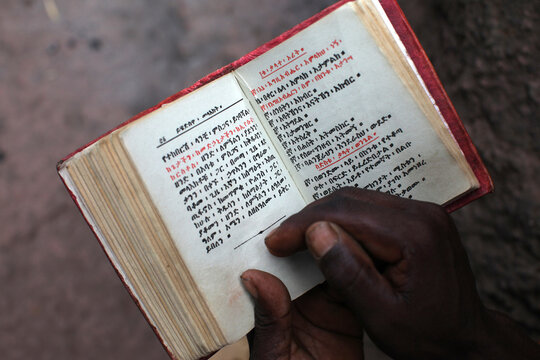 Faithful reading outside Bieta Ghiorghis (Saint George's House) church in Lalibela