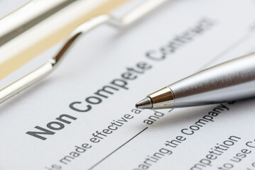 Blue pen on a non compete contract. Noncompete contract is an agreement between employee and...