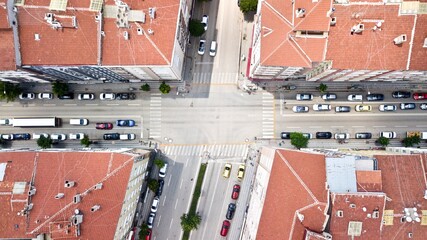 Aerial view of the intersection road, city vehicles and crosswalk between buildings